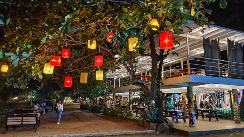 A vibrant restaurant adorned with lanterns hanging from trees