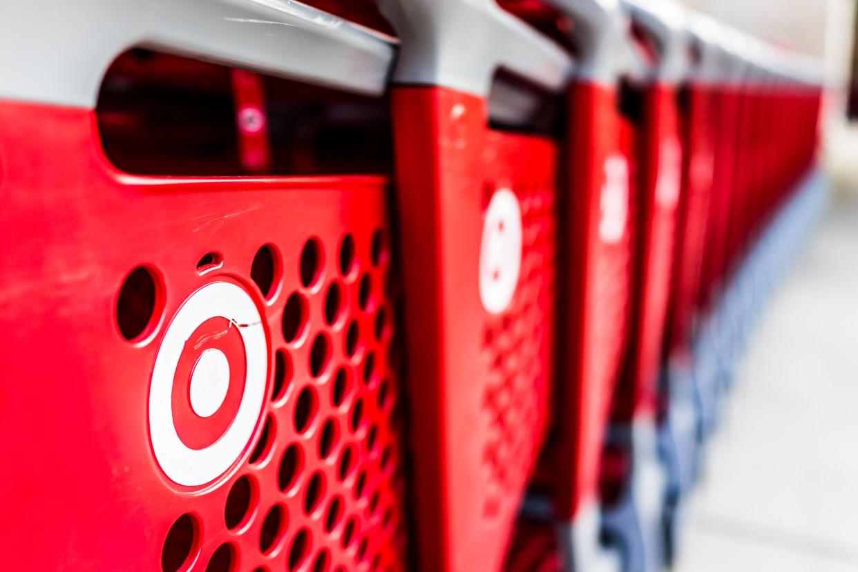 A row of red plastic Target shopping carts in front of a Target store, selective focus on the left, gradient blur on the right