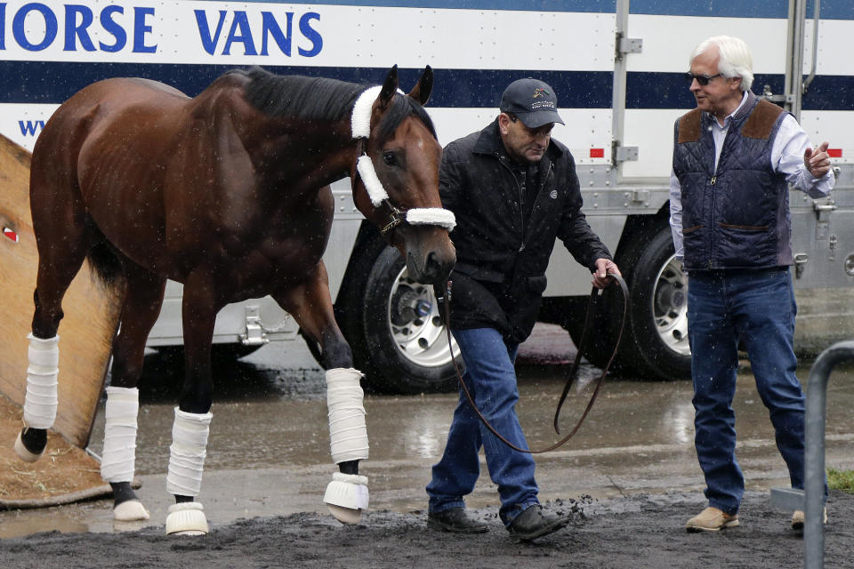 FILE - In this June 2, 2015, file photo, Kentucky Derby and Preakness Stakes winner American Pharoah is led off a transport van by assistant trainer Jimmy Barnes as trainer Bob Baffert, right, gestures, at Belmont Park in Elmont, N.Y. Baffert is undefeated taking the Kentucky Derby winner to the Preakness, but for the first time in 20 years he’ll do so without assistant trainer Jimmy Barnes, who broke his right wrist in a paddock accident at Churchill Downs. (AP Photo/Julie Jacobson, File)