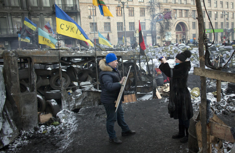 Visitors take photographs of each other at the barricade in central Kiev, Ukraine, Friday, Jan. 31, 2014. Negotiations between the authorities and the opposition on finding a way out of the crisis appeared to have stalled on Thursday, after Yanukovych took an unexpected sick leave and told opposition leaders that it was now up to them to make concessions. (AP Photo/Darko Bandic)