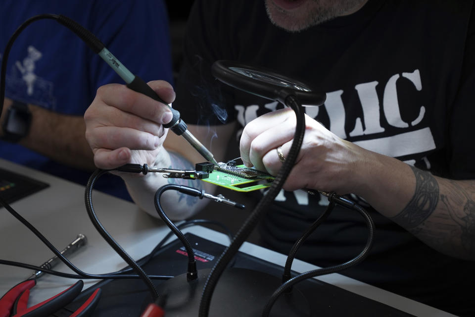 A workshop participant solders components for a LightSound device at the New England Sci-Tech education center in Natick, Mass., on March 2, 2024. The device is the result of a collaboration between Wanda Díaz-Merced, an astronomer who is blind, and Harvard astronomer Allyson Bieryla. Díaz-Merced regularly translates her data into audio to analyze patterns for her research. (AP Photo/Mary Conlon)