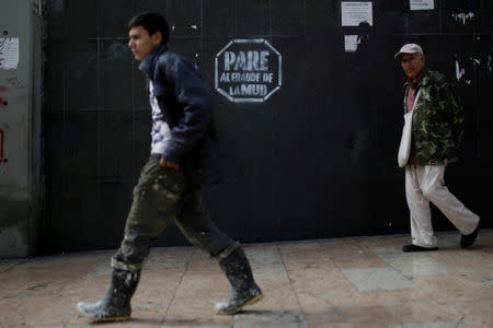 People walk past a graffitti that reads "Stop the fraud of the MUD" in Caracas, Venezuela February 6, 2017. REUTERS/Marco Bello