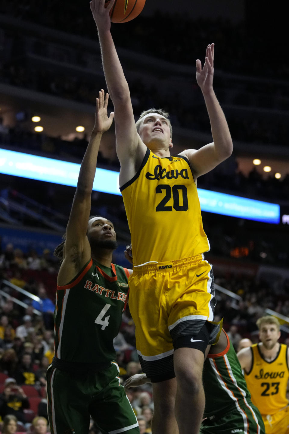 Iowa forward Payton Sandfort (20) drives to the basket over Florida A&M guard Hantz Louis-Jeune (4) during the first half of an NCAA college basketball game, Saturday, Dec. 16, 2023, in Des Moines, Iowa. (AP Photo/Charlie Neibergall)