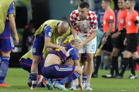 Japan's Takuma Asano, center, is comforted by Croatia's Ivan Perisic, after Croatia's win in the World Cup round of 16 soccer match between Japan and Croatia at the Al Janoub Stadium in Al Wakrah, Qatar, Monday, Dec. 5, 2022. (AP Photo/Eugene Hoshiko)