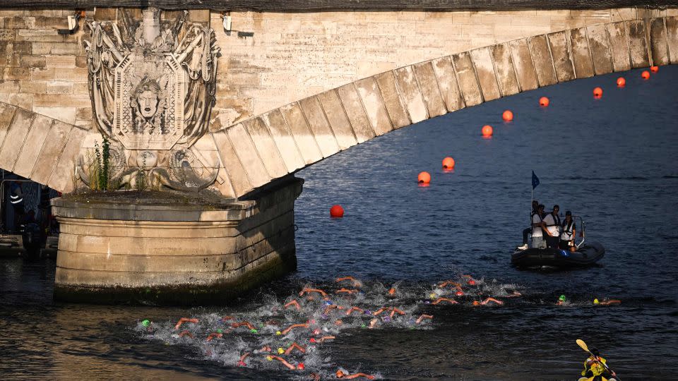 Triathlon athletes swim in the Seine river during the men's 2023 World Triathlon Olympic Games test event in Paris on August 18, 2023. - Emmanuel Dunand/AFP/Getty Images