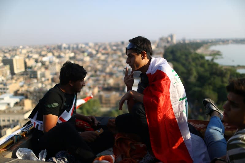 Iraqi demonstrators are seen on the top of the high-rise building, called by Iraqi the Turkish Restaurant Building, during anti-government protests in Baghdad