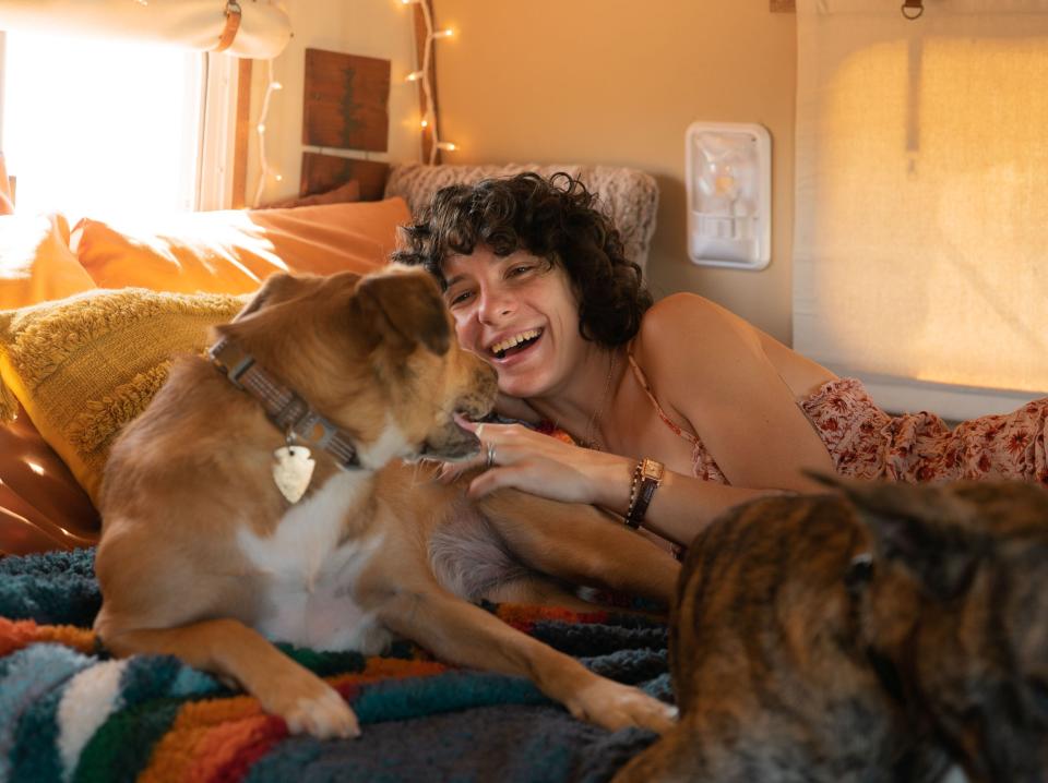 Casey Smith lying on the bed with one of their dogs.