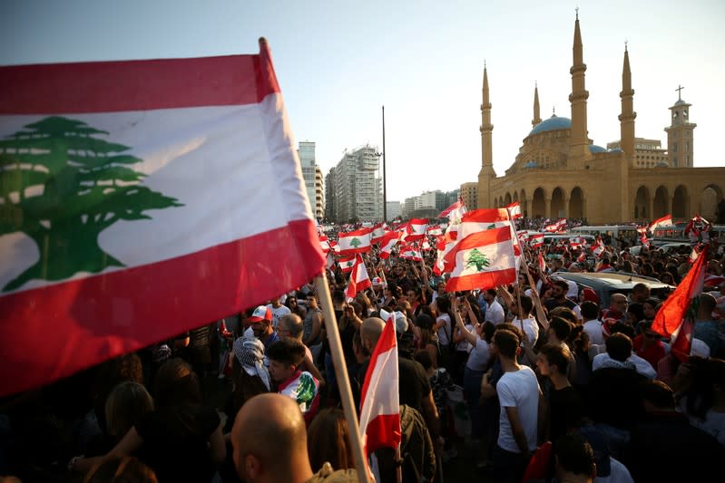 Demonstrators carry national flags during an anti-government protest near Al-Amin mosque in downtown Beirut