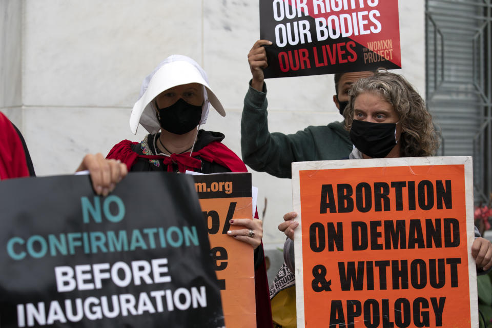 Protesters opposed to the confirmation of President Donald Trump's Supreme Court nominee Amy Coney Barrett, rally on Capitol Hill, in Washington, Tuesday, Oct. 13, 2020. (AP Photo/Jose Luis Magana)