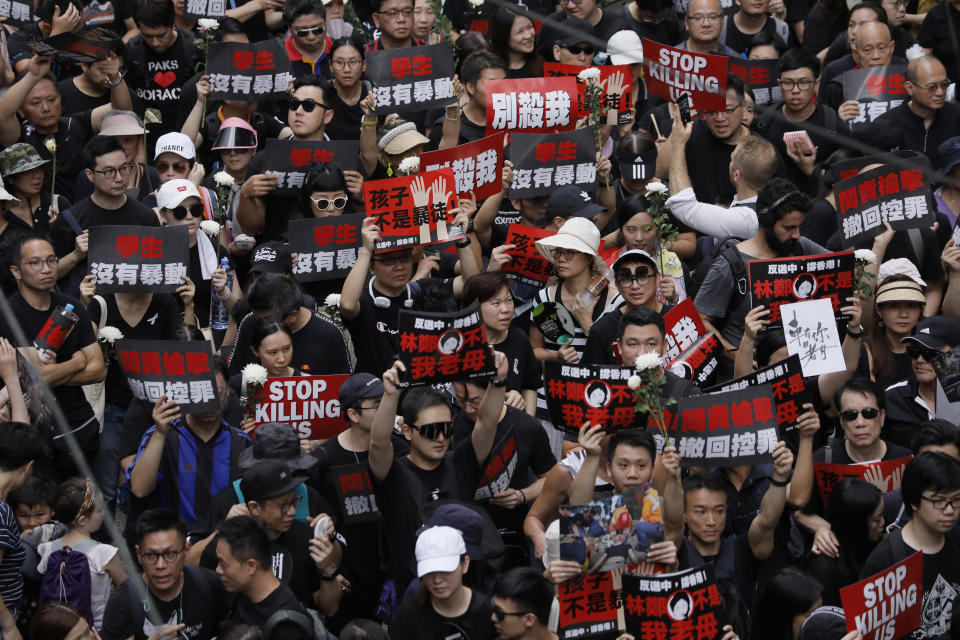 Thousands of protesters shouting slogans and carrying signs march through the streets against an extradition bill on Sunday, June 16, 2019, in Hong Kong. Tens of thousands of Hong Kong residents, mostly in black, have jammed the city's streets Sunday to protest the government's handling of a proposed extradition bill. (AP Photo/Vincent Yu)