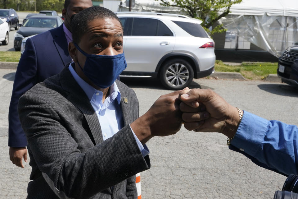 Virginia Democratic gubernatorial candidate Lt. Gov. Justin Fairfax gives a fist bump to a supporter outside Pink Fish restaurant in Hampton, Va., Thursday, April 8, 2021. Fairfax has long had lofty political ambitions, and despite facing two unresolved allegations of sexual assault he’s pressing forward with a bid for governor. (AP Photo/Steve Helber)