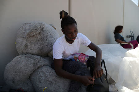 Maseeka Owens, 18, sits on a giant teddy bear as she visits friends who are homeless in Los Angeles, California, U.S. March 29, 2018. Picture taken March 29, 2018. REUTERS/Lucy Nicholson