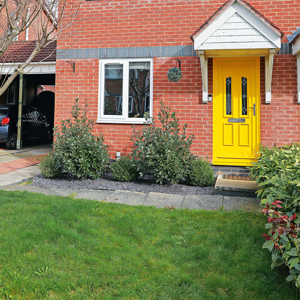 Front garden with lawn in front of brick house