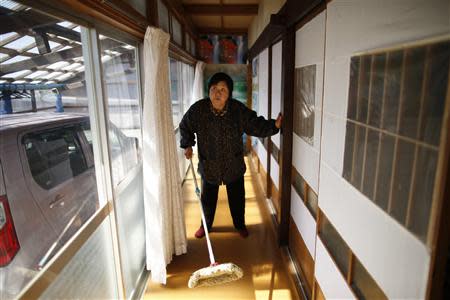 Kimiko Koyama, 69, who evacuated from the Miyakoji area of Tamura three years ago, dusts off her house after she returned to her home with her husband Toshio, 76, in Tamura, Fukushima prefecture April 1, 2014. REUTERS/Issei Kato