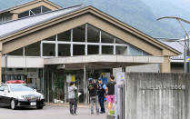 <p>A police officer talks with visitors in front of a facility for the handicapped where a number of people were killed and dozens injured in a knife attack Tuesday, July 26, 2016, in Sagamihara, outside Tokyo. (Kyodo News via AP)</p>