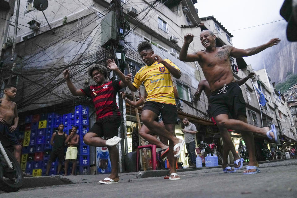 FILE - Youth perform a street dance style known as passinho for their social media accounts, in the Rocinha favela of Rio de Janeiro, Brazil, April 11, 2024. The passinho, or "little step", created in the 2000s by kids in Rio's favelas, was declared an "intangible cultural heritage" by state legislators, bringing recognition to a cultural expression born in the sprawling working-class neighborhoods. (AP Photo/Silvia Izquierdo, File)