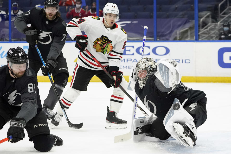 Tampa Bay Lightning goaltender Andrei Vasilevskiy (88) makes a pad save on a deflection by Chicago Blackhawks center Pius Suter (24) during the first period of an NHL hockey game Saturday, March 20, 2021, in Tampa, Fla. Defending for Tampa Bay is defenseman Erik Cernak (81). (AP Photo/Chris O'Meara)