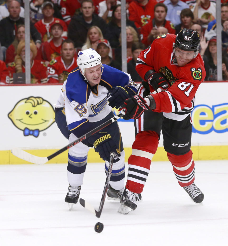 St. Louis Blues defenseman Jay Bouwmeester (19) deflects a shot by Chicago Blackhawks right wing Marian Hossa (81) during the second period in Game 3 of a first-round NHL hockey Stanley Cup playoff series game Monday, April 21, 2014, in Chicago. (AP Photo/Charles Rex Arbogast)