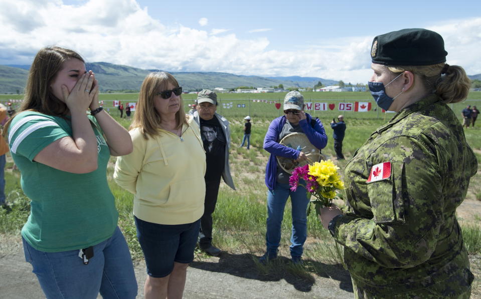 Royal Canadian Air Force Public Affairs Officer Lt. Alexandra Hejduk, right, speaks with retired nurse Dana Hings, center, and her daughter Jenna Phillips at the Kamloops airport in Kamloops, British Columbia, Monday, May 18, 2020. Hings and Phillips were first on the scene to attend to Canadian Forces Snowbirds Capt. Jenn Casey, who died on Sunday after the jet she was in crashed after takeoff. (Jonathan Hayward/The Canadian Press via AP)