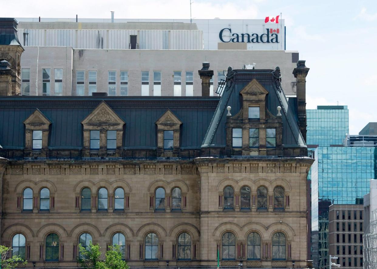 A Canadian flag flies near near Parliament Hill in Ottawa. A new report says the Liberal government has failed to recognize the gravity of the threat of foreign interference. (Adrian Wyld/Canadian Press - image credit)