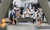 People pray for the victims of the U.S. 1945 atomic bombing, at the Peace Memorial Park in Hiroshima, Japan