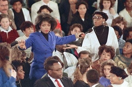 Daytime talk show hostess Oprah Winfrey gestures to the crowd at the Southwestern High School in Baltimore on Nov. 29, 1988, for quiet during the taping of her show on school violence.