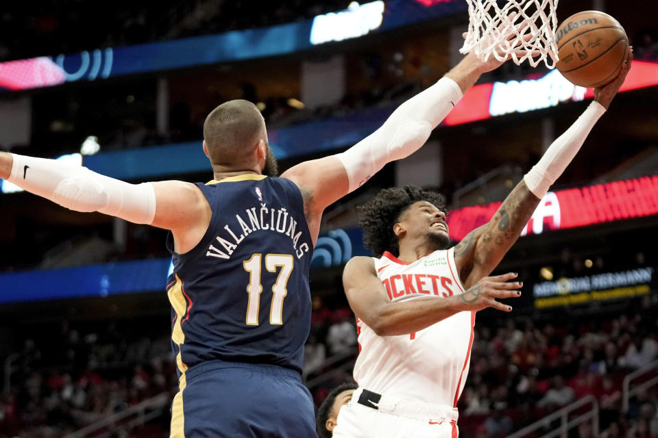 Houston Rockets guard Jalen Green, right, drives to the basket as New Orleans Pelicans center Jonas Valanciunas defends during the first half of an NBA basketball game Wednesday, Jan. 31, 2024, in Houston. (AP Photo/Eric Christian Smith)