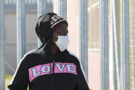 In this photo taken Thursday, April 2, 2020 a woman stands outside a testing clinic in Khayelitsha, Cape Town, South Africa. South Africa, one of the world's most unequal countries with a large population vulnerable to the new coronavirus, may have an advantage in the coronavirus outbreak, honed during years battling HIV and tuberculosis: the know-how and infrastructure to conduct mass testing. (AP Photo/Nardus Engelbrecht)