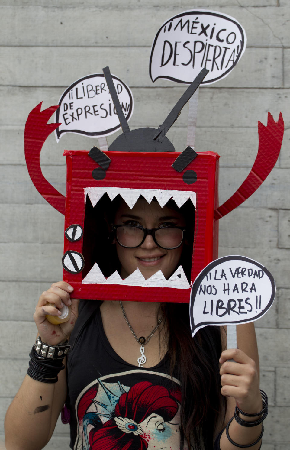 A student holds signs during a demonstration to protest a possible return of the old ruling Institutional Revolutionary Party (PRI) and against what they perceive as a biased coverage by major Mexican TV networks directed in favor of PRI's candidate Enrique Pena Nieto in Mexico City, Wednesday, May 23, 2012. Mexico will hold presidential elections on July 1. (AP Photo/Eduardo Verdugo)