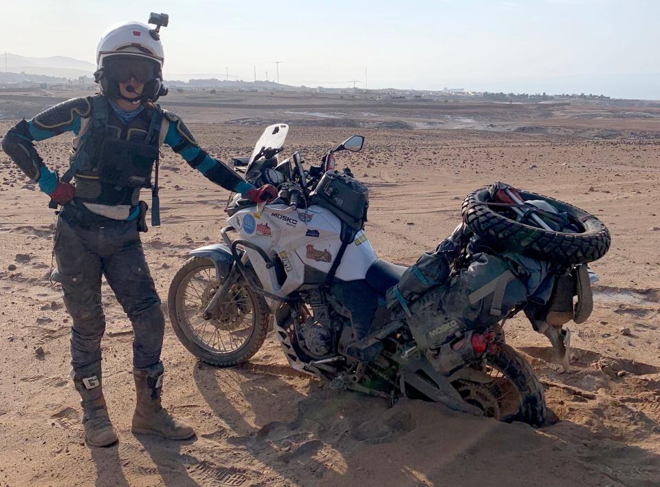 Bridget McCutchen, is shown with her motorcycle stuck in the sand in southern Peru in February 2023, while on her round-the-world motorcycle trip.