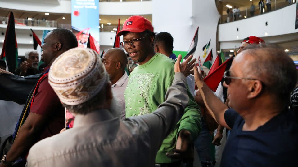 Advocate Tembeka Ngcukaitobi (C), a member of the South African legal team, is greeted by a supporter following a two-day hearing against Israel at the International Court of Justice (ICJ), at the OR Tambo International Airport in Ekurhuleni, South Africa on January 14. - Alaister Russell/AFP/Getty Images