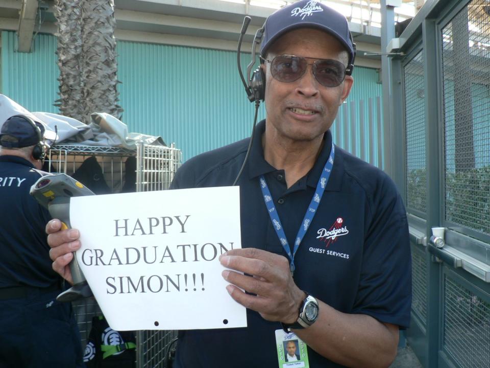 Dodger Stadium worker Errol Coffey wishes a happy high school graduation to Dodgers fan Simon Brooks.