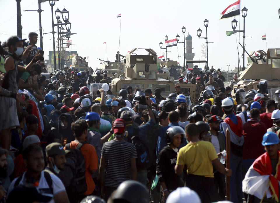 Iraqi Army soldiers try to prevent anti-government protesters from crossing the al- Shuhada (Martyrs) bridge in central Baghdad, Iraq, Wednesday, Nov. 6, 2019. Tens of thousands of people have taken to the streets in recent weeks in the capital, Baghdad, and across the Shiite south, demanding sweeping political change. (AP Photo/Hadi Mizban)