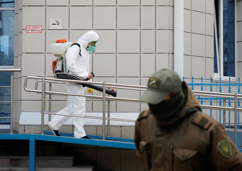 A specialist sprays disinfectant at a bus station in Stavropol