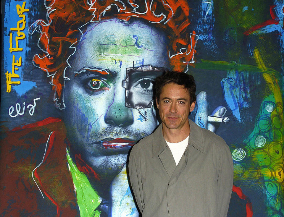 Robert Downey Jr stands in front of his album art