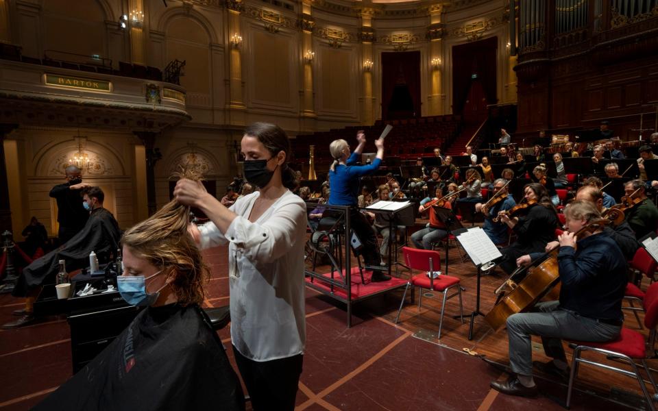 Customers get a haircut during a rehearsal at the Concertgebouw - AP