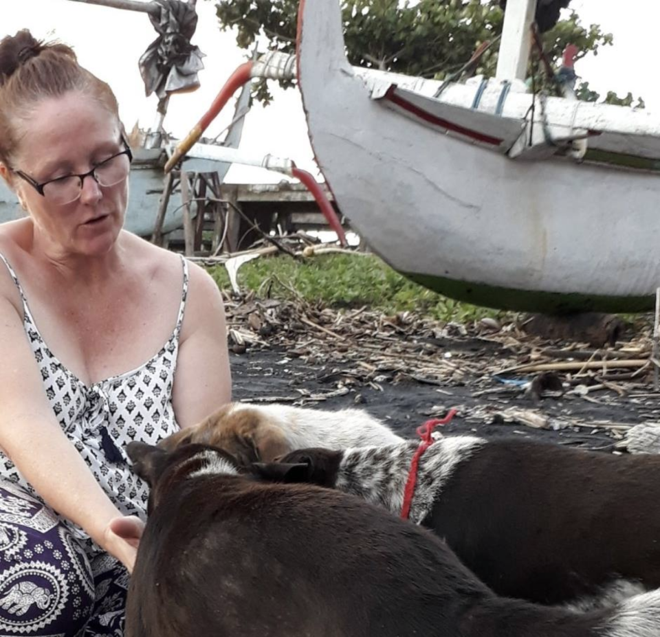 Susan O'Brien with three dogs in Bali.