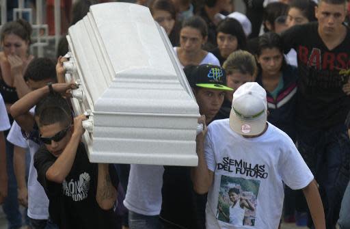 Unos amigos y parientes llevan el ataúd del rapero de 14 años Juan Camilo Giraldo, conocido como 'Morocho', durante su funeral en Medellín, Colombia, en enero de 2014. El joven murió tras ser disparado por un pistolero en la Comuna 13 (AFP/Archivos | Raúl Arboleda)