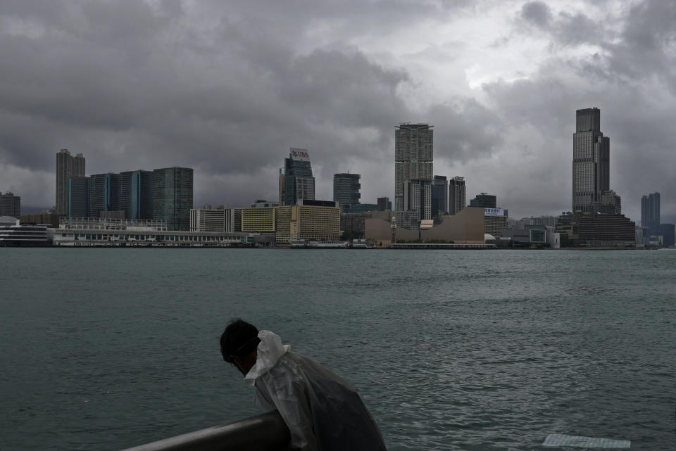 A man stands at the waterfront of Victoria Harbour in Hong Kong Wednesday, Aug. 19, 2020. Typhoon Higos weakened to a strong topical storm after making landfall in Zhuhai city on Wednesday morning on China's southern coast. (AP Photo/Vincent Yu)