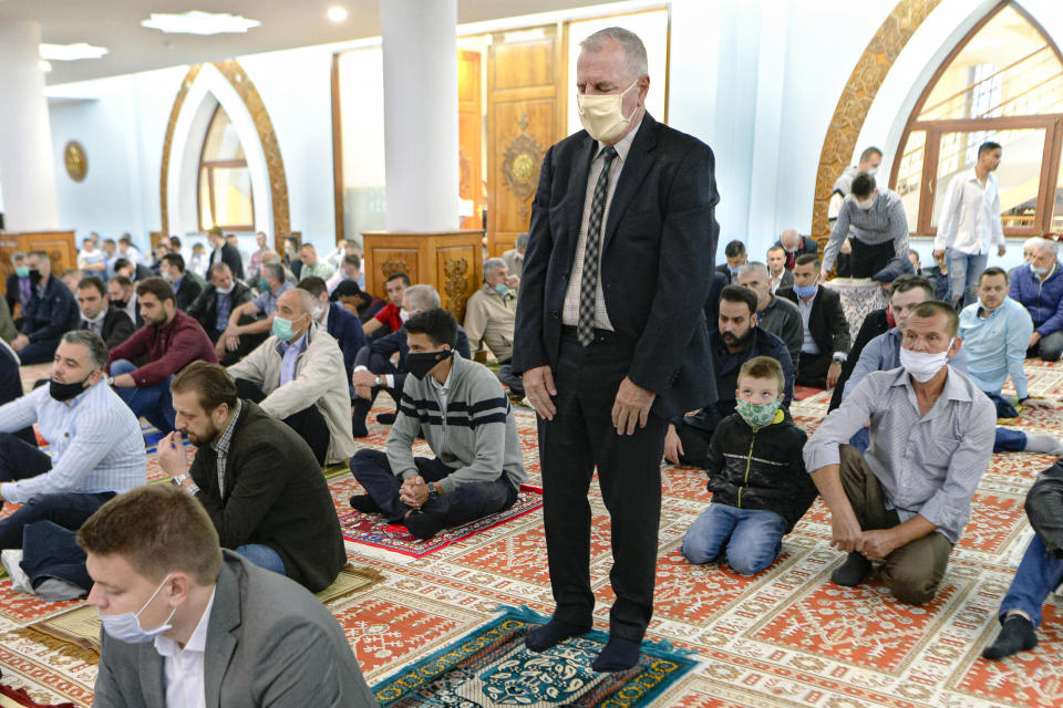 Bosnian muslims, some wearing face masks to protect themselves from the COVID-19 infection, attend Eid al-Fitr prayers in Sarajevo, Bosnia, Sunday, May 24, 2020. Muslims worldwide are marking a muted religious festival of Eid al-Fitr, the end of the fasting month of Ramadan _ a usually joyous three-day celebration that has been significantly toned down due to the new coronavirus outbreak.(AP Photo/Kemal Softic)