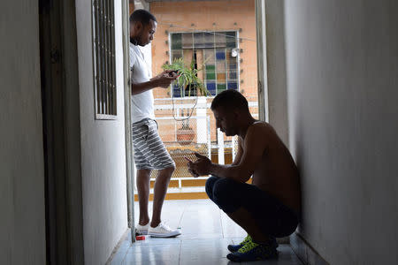 Cubans stranded in Mexico check their mobile phones at a hotel after fellow nationals were deported in Tapachula, Mexico January 20, 2017. REUTERS/Jose Torres