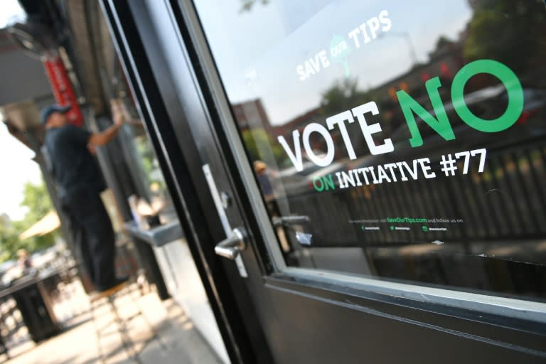 A sign calling on Washington residents to reject a ballot measure called Initiative 77, which would impact tipping by instituting a higher minimum wage for restaurant workers