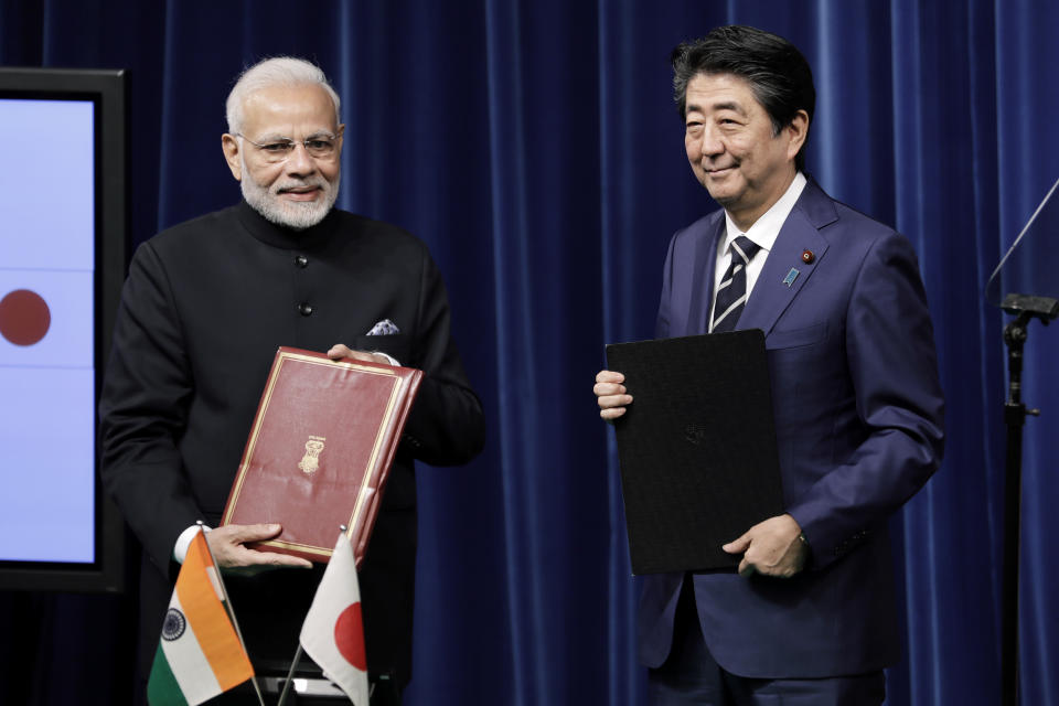 Indian Prime Minister Narendra Modi, left, and Japan's Prime Minister Shinzo Abe hold signed documents during a joint news conference at Abe's official residence in Tokyo Monday, Oct. 29, 2018. (Kiyoshi Ota/Pool Photo via AP)