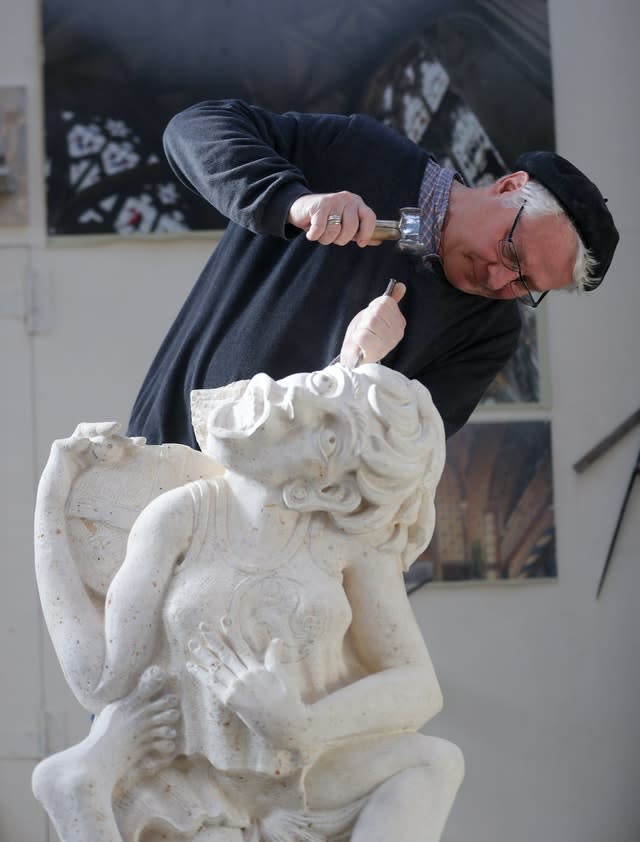 Master mason Pascal Mychalysin works on the cheese rolling gargoyle (David Davies/PA).