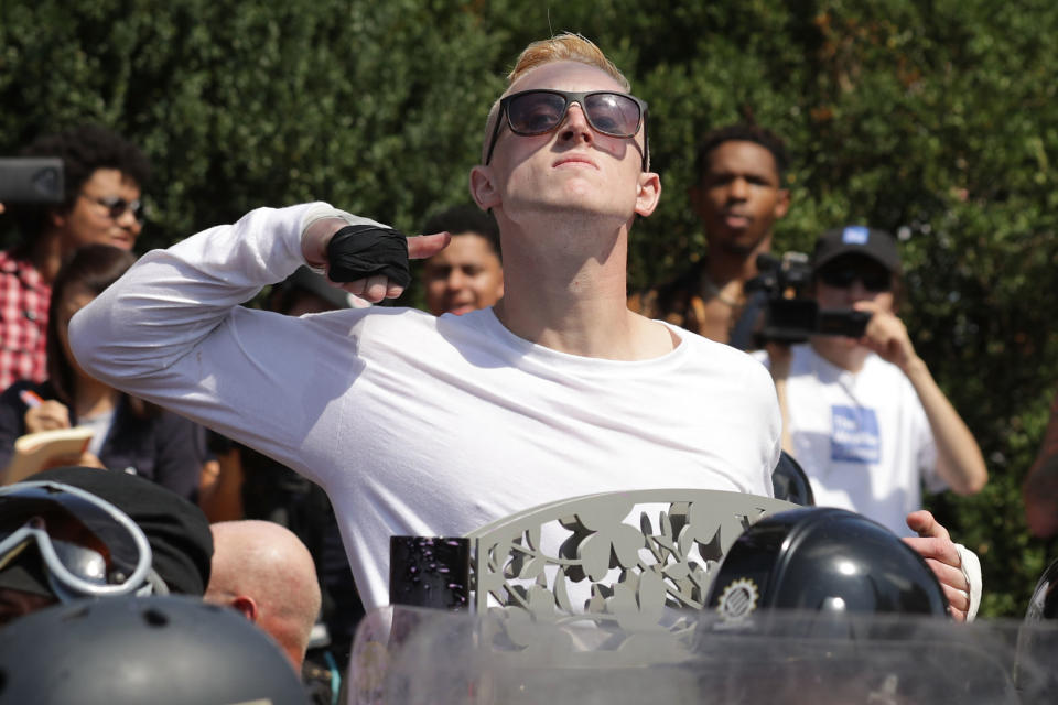 A man makes a slashing motion across his throat toward&nbsp;counter-protesters as he marches with other white nationalists&nbsp;and neo-Nazis during the "Unite the Right" rally.