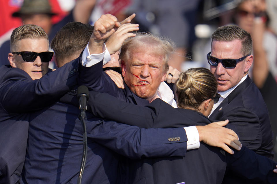 El expresidente y virtual candidato presidencial republicano Donald Trump levanta el puño mientras recibe ayuda para bajar del estrado en un mitin de campaña en Butler, Pensilvania, el sábado 13 de julio de 2024. (AP Foto/Gene J. Puskar)