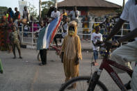 A kid wears a costume as supporters of the Gambian President Adama Barrow celebrate the partial results that give the lead to their candidate during the counting ballots in Gambia's presidential election, in Banjul, Gambia, Sunday, Dec. 5, 2021. Election officials in the West African nation of Gambia have started counting marble votes after polls closed for the first presidential election in decades that does not include former dictator Yahya Jammeh as a candidate. (AP Photo/Leo Correa)