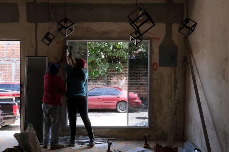 Trabajadores instalan una ventana en una nueva cafetería en el pueblo de Conchagua, cerca del sitio proyectado para la Ciudad Bitcoin según el presidente de El Salvador, Nayib Bukele, en Conchagua