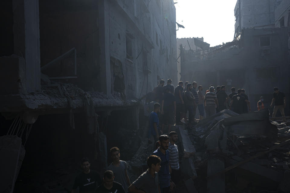 Palestinians search for bodies and survivors in the rubble of a residential building leveled in an Israeli airstrike, Al Shati Refugee Camp Thursday, Oct. 12, 2023. Israel's retaliation has escalated after Gaza's militant Hamas rulers launched an unprecedented attack on Israel Saturday, killing over 1,200 Israelis and taking captive dozens. Heavy Israeli airstrikes on the enclave has killed over 1,200 Palestinians. (AP Photo/Fatima Shbair)