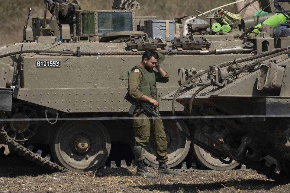 An Israeli soldier wipes out his head next to a stationed tank near the border with Lebanon, in Israel, Saturday Oct. 14, 2023. (AP Photo/Petros Giannakouris)